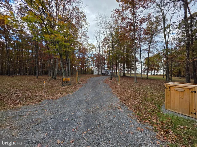 a view of a house with large tree and wooden fence