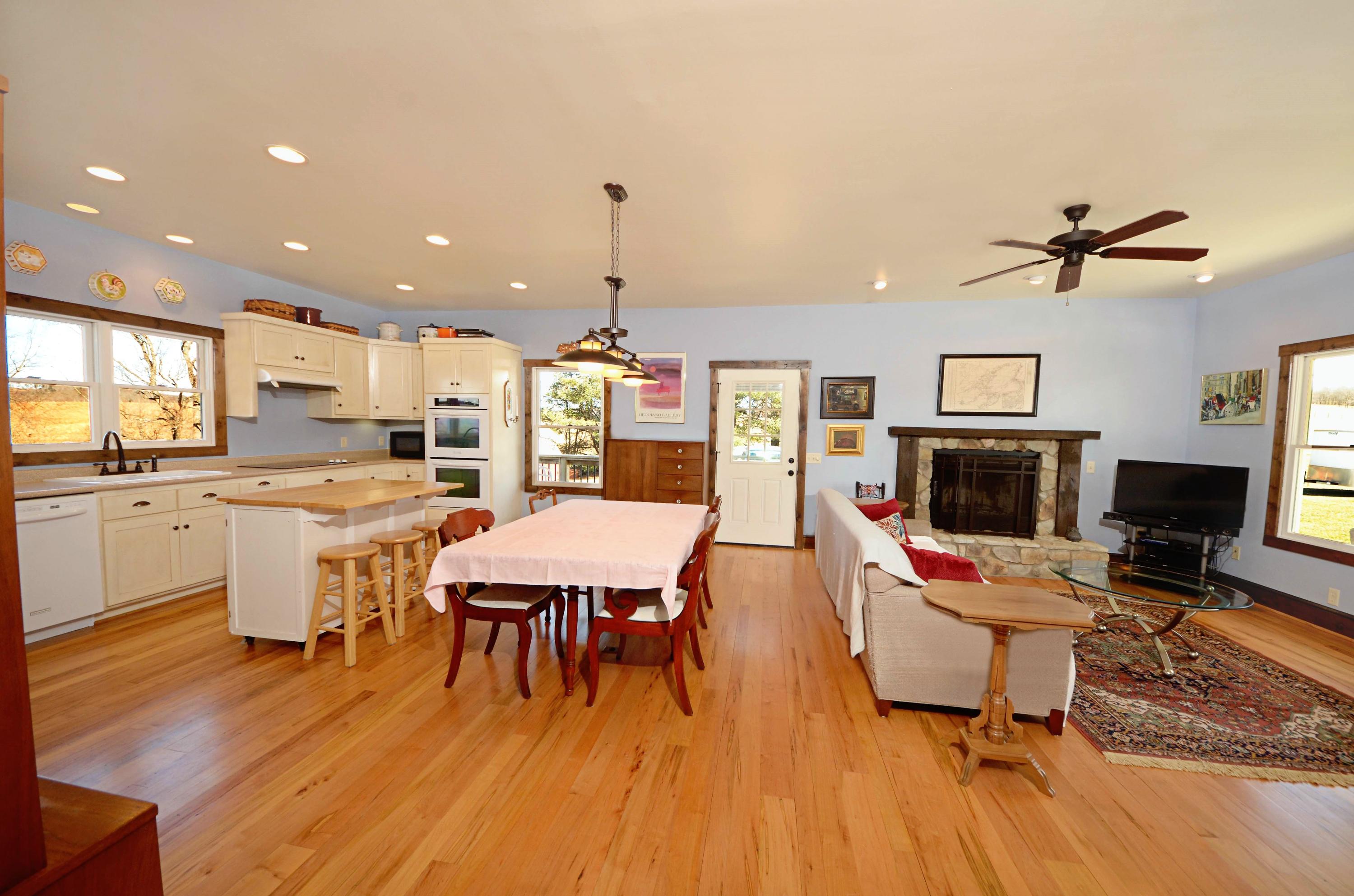 657 Poor Farm Road Southeast Floyd, VA 24091 - Photo 21 of 40 a living room with furniture a fireplace and kitchen view