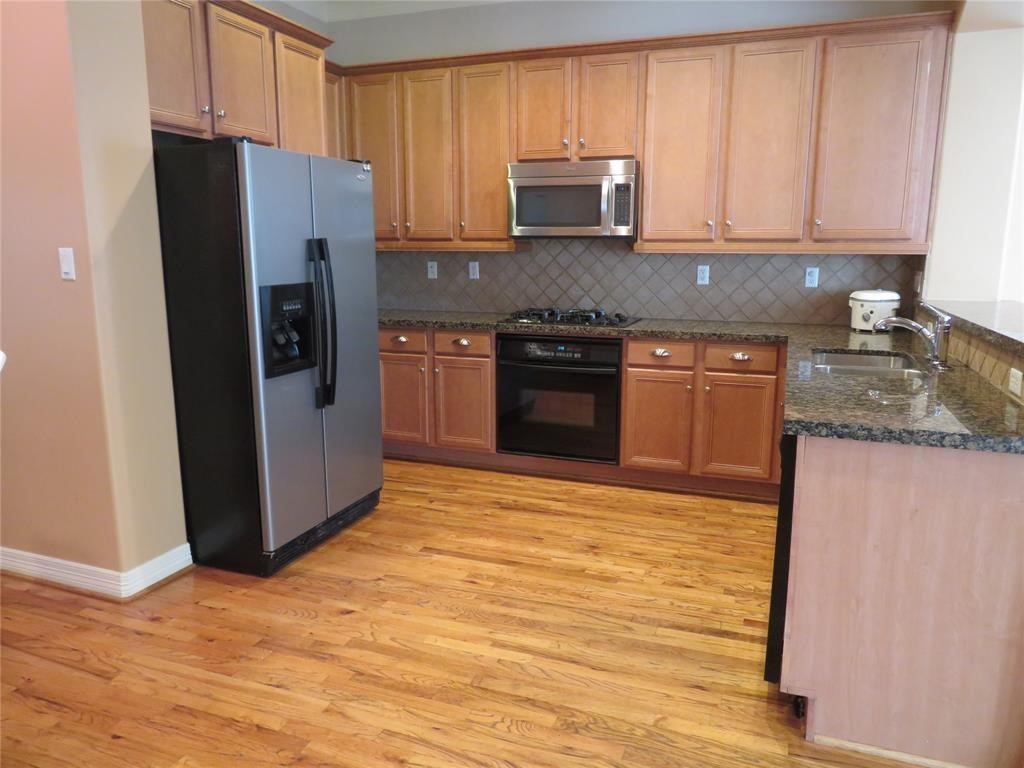 5908 Center Street Houston, TX 77007 - Photo 3 of 17 a kitchen with stainless steel appliances granite countertop a refrigerator stove top oven a sink and dishwasher