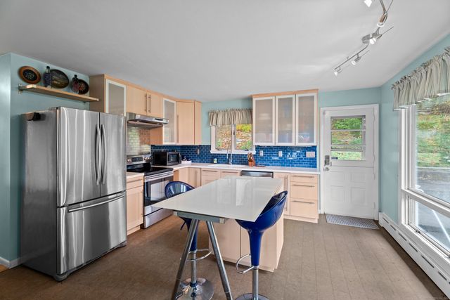 a kitchen with refrigerator cabinets and wooden floor