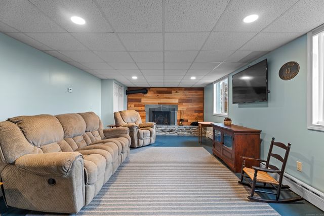 a living room with furniture a flat screen tv and kitchen view