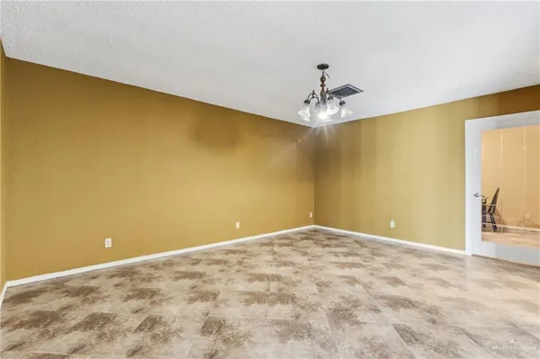 a view of a big room with windows and chandelier fan