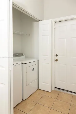 a utility room with cabinets washer and dryer