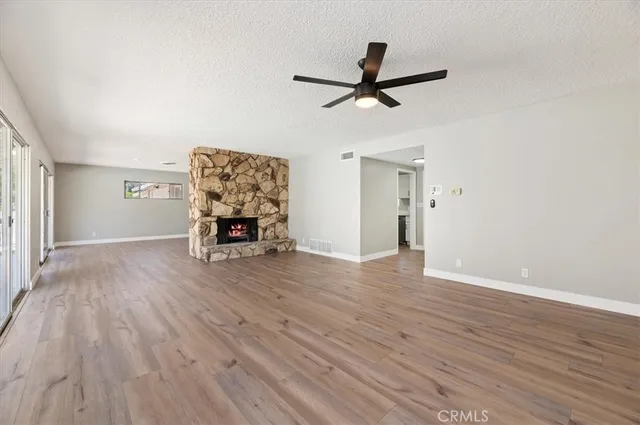 a living room with wooden floor and a ceiling fan