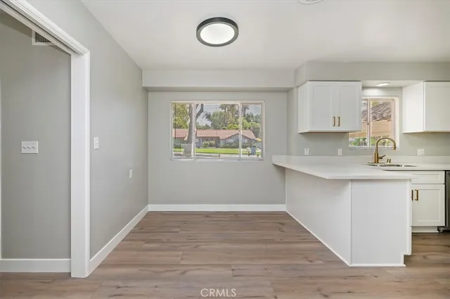 a kitchen with granite countertop a window and a wooden floor