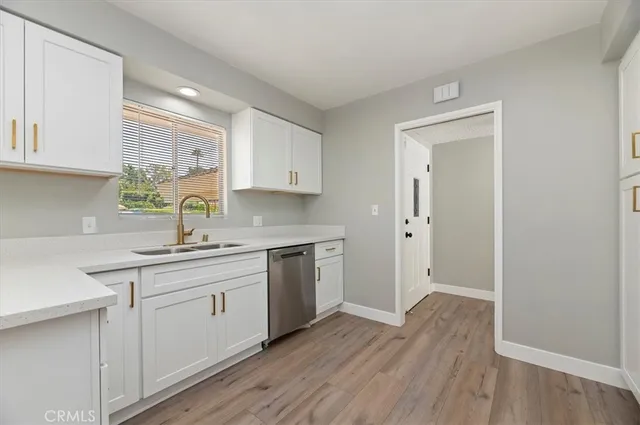 a kitchen with a sink cabinets stainless steel appliances and a window