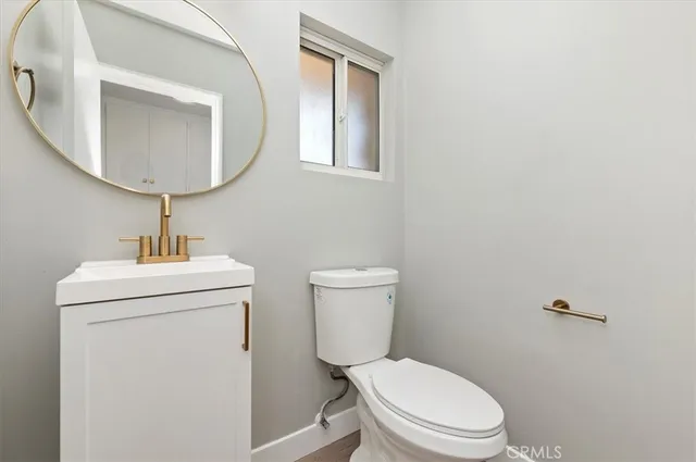 a bathroom with a toilet a sink and mirror