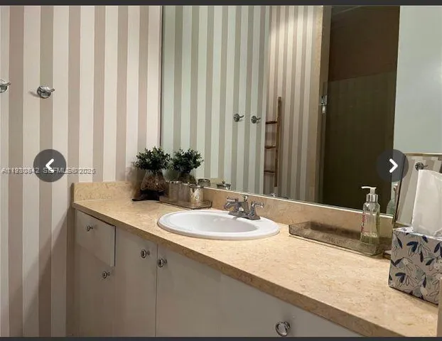 a kitchen with a sink and a stove with wooden floor