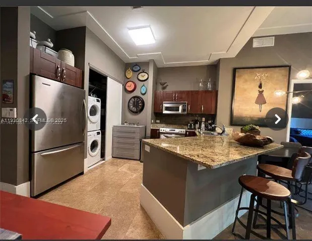 a kitchen with stainless steel appliances granite countertop a refrigerator and a stove