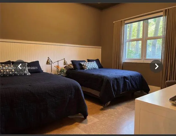 a bedroom with two beds and a window