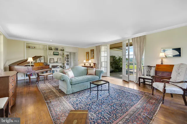 a living room with furniture and floor to ceiling windows