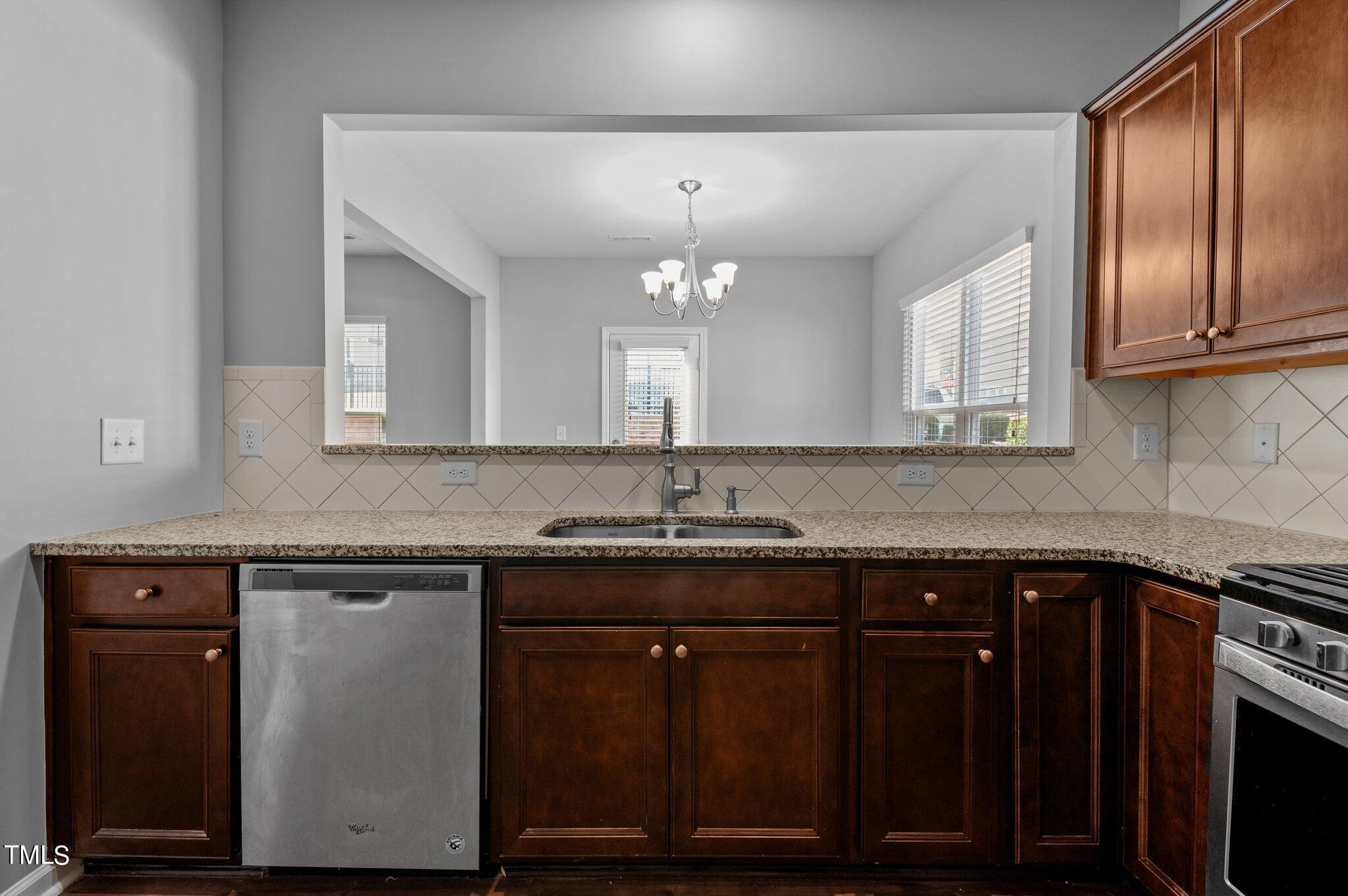 1033 Mirbeck Lane Durham, NC 27713 - Photo 11 of 37 a kitchen with sink cabinets and chandelier