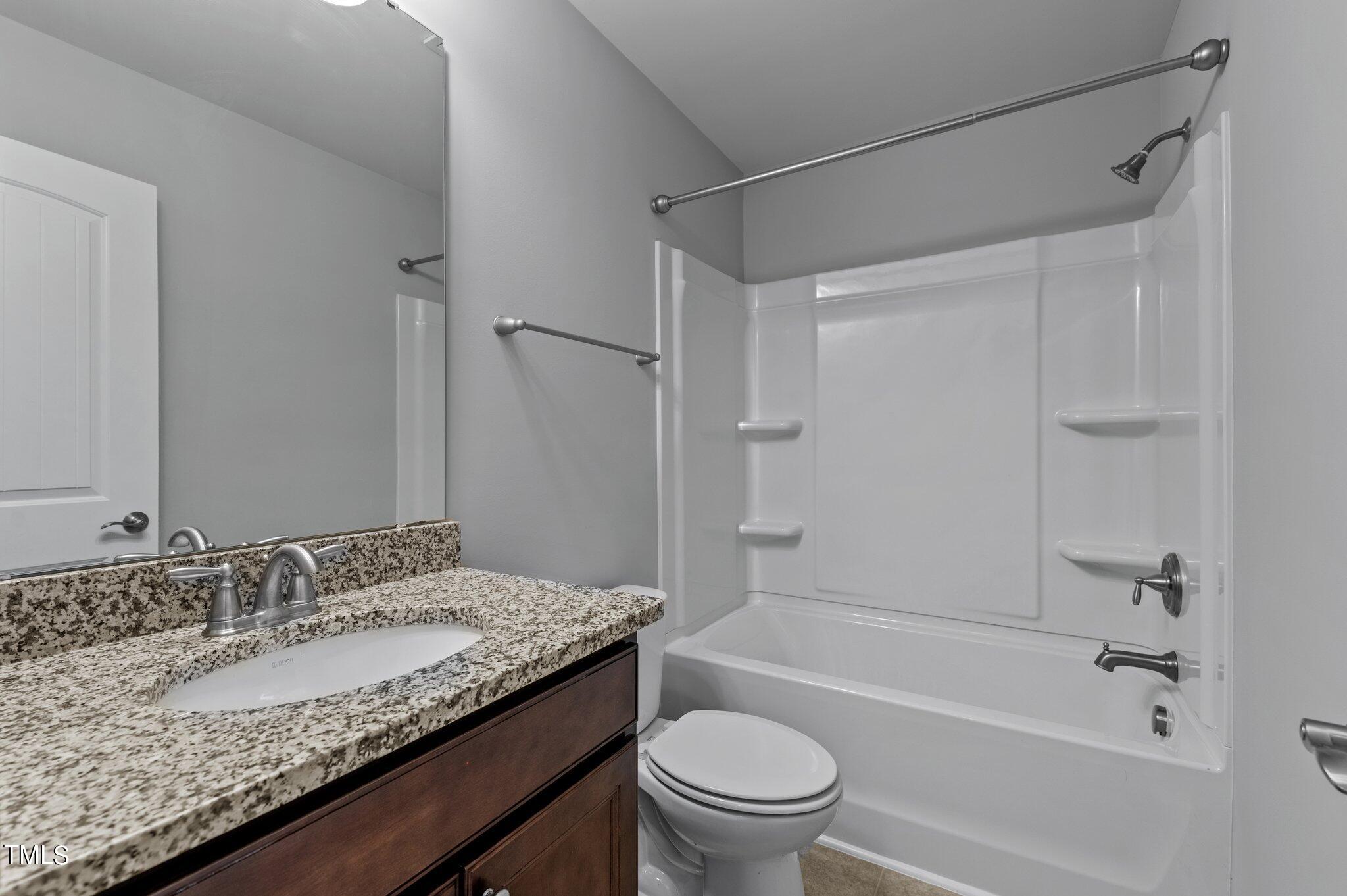 1033 Mirbeck Lane Durham, NC 27713 - Photo 22 of 37 a bathroom with a granite countertop sink a toilet and shower