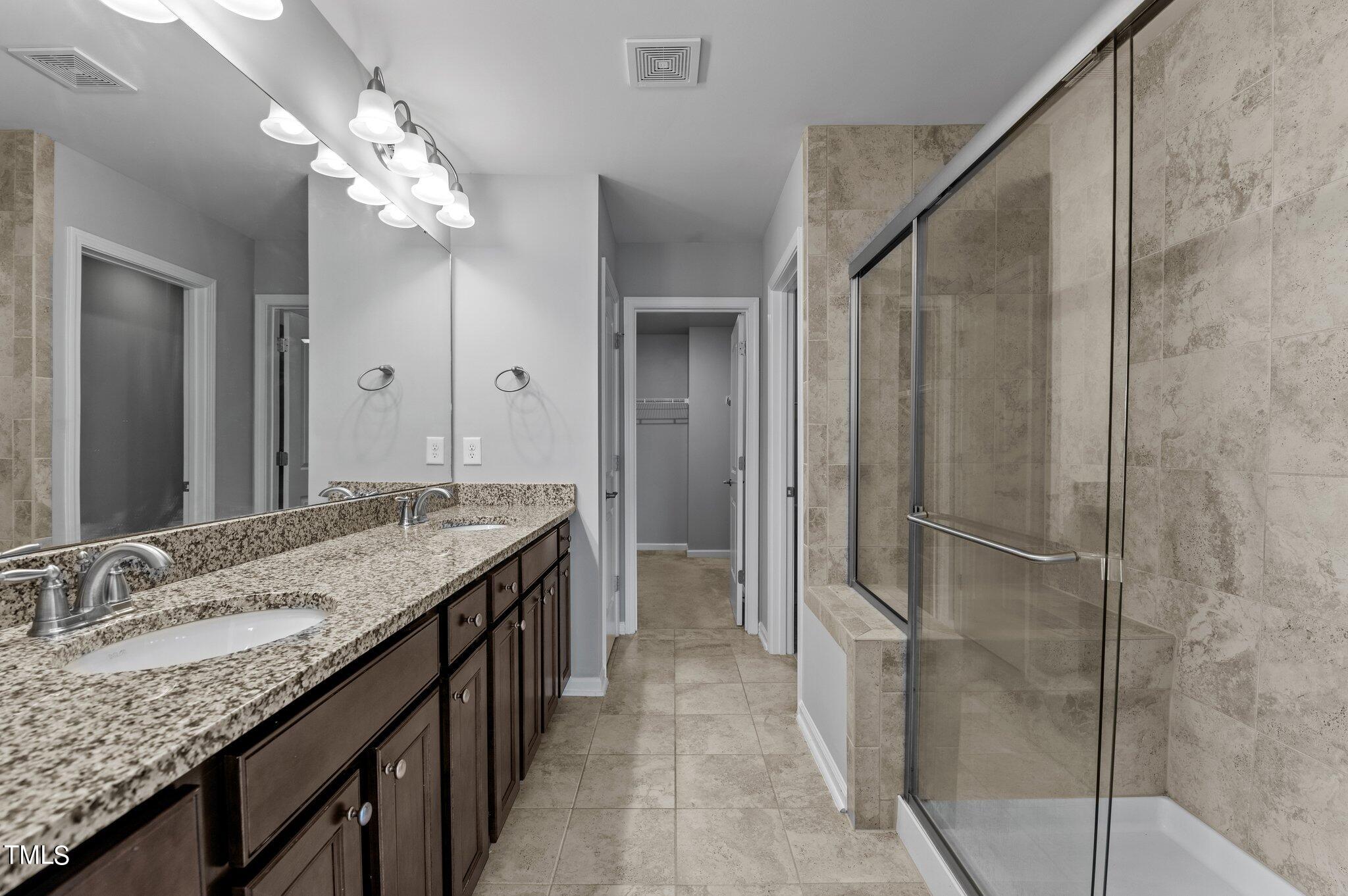 1033 Mirbeck Lane Durham, NC 27713 - Photo 28 of 37 a bathroom with a granite countertop sink a mirror and a shower
