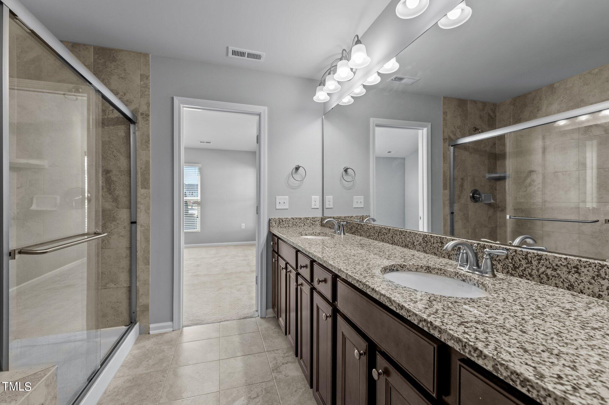 1033 Mirbeck Lane Durham, NC 27713 - Photo 29 of 37 a bathroom with a granite countertop sink a large mirror and a shower