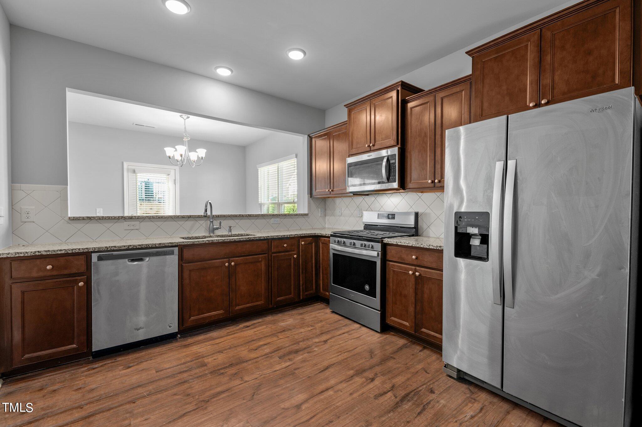 1033 Mirbeck Lane Durham, NC 27713 - Photo 8 of 37 a kitchen with granite countertop a refrigerator stove top oven and sink