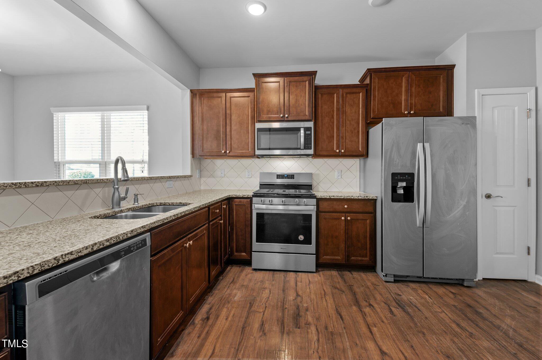 1033 Mirbeck Lane Durham, NC 27713 - Photo 10 of 37 a kitchen with stainless steel appliances granite countertop a refrigerator stove and sink