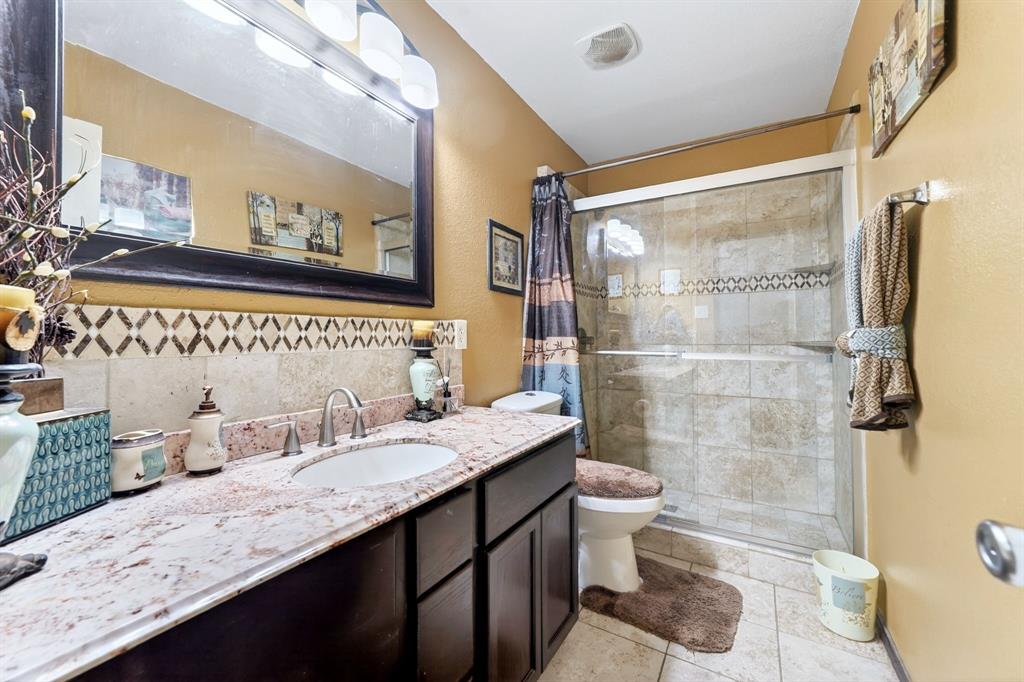 511 Chestnut Trail Forney, TX 75126 - Photo 24 of 32 Bathroom vanity featuring a light-colored countertop, undermount sink, and dark wood cabinetry
