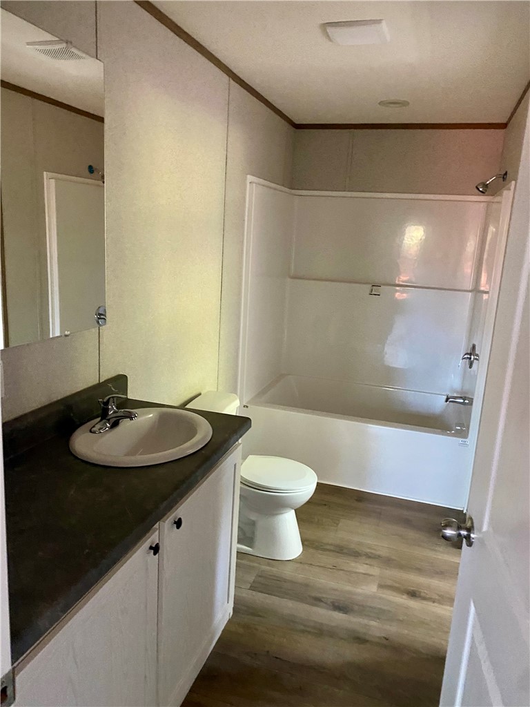 712 Carl Baker Road Starr, SC 29684 - Photo 5 of 10 Functional bathroom design incorporates durable wood-look flooring alongside a classic tub and shower surround.