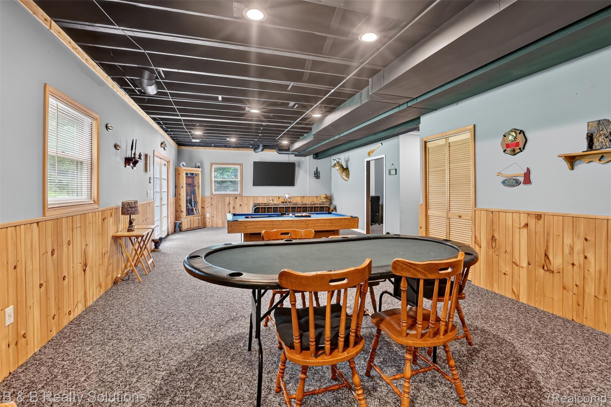 3097 East Burnside Road North Branch, MI 48461 - Photo 35 of 52 Spacious recreation room featuring wood paneling, light blue painted walls, and textured carpet flooring