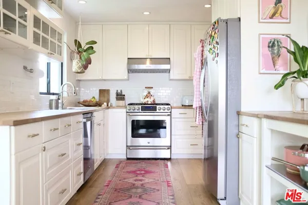 a kitchen with white cabinets and white appliances