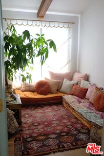 a living room with large stone and a potted plant