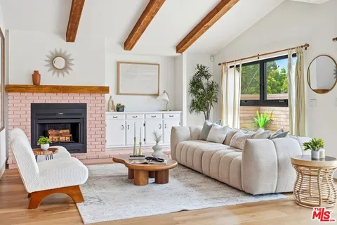 a living room with furniture fireplace and a large window