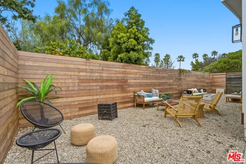 a backyard of a house with barbeque oven table and chairs