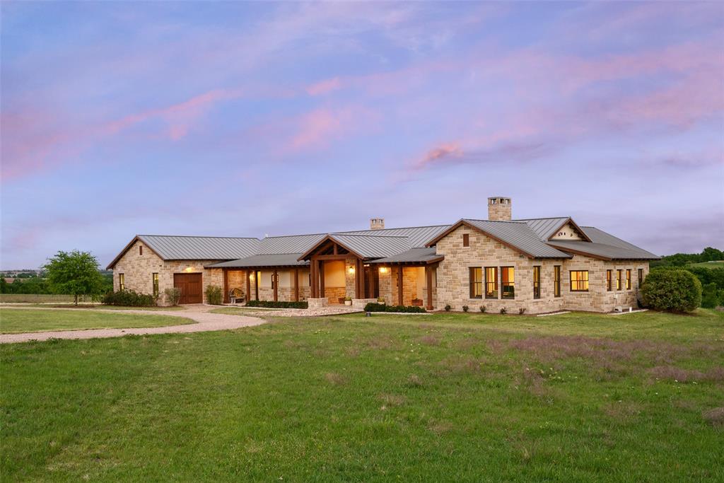 a front view of a house with a yard and lake view