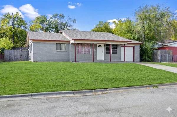 a view of a house with a yard and a large tree