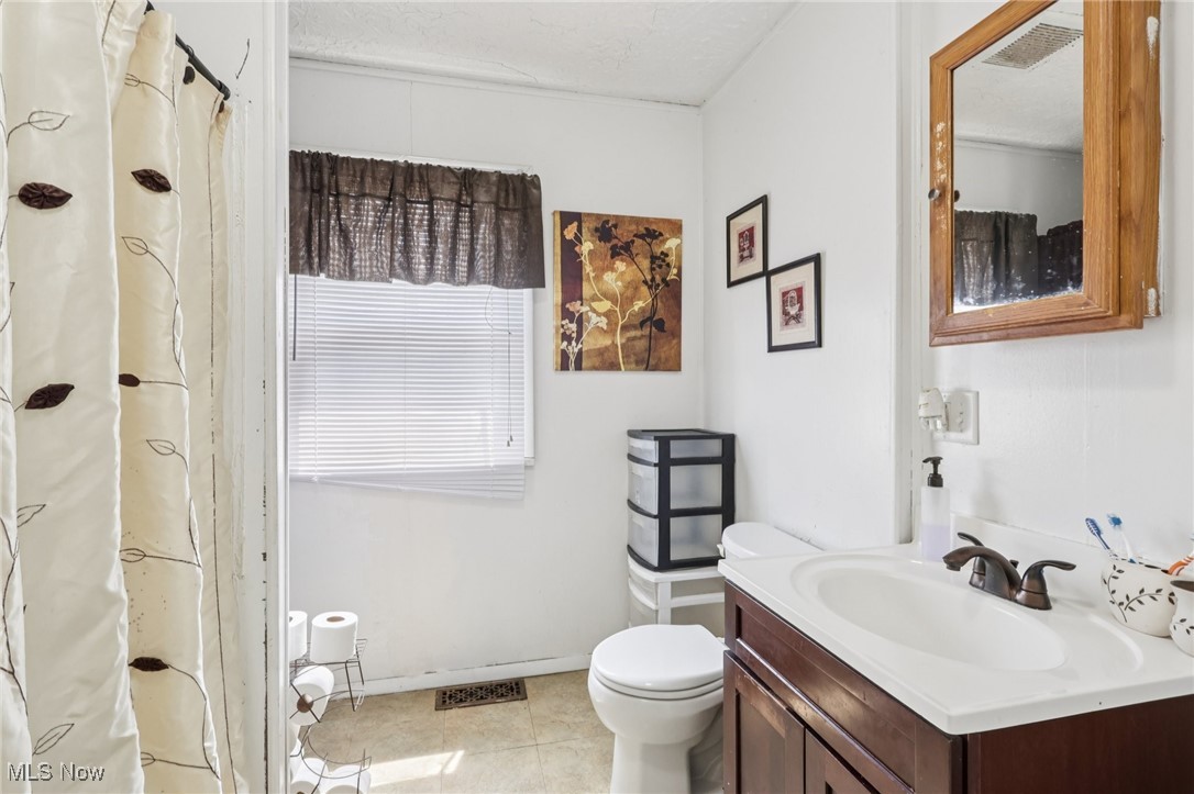 764 Chalker Street Akron, OH 44310 - Photo 16 of 34 Bathroom with vanity, curtained shower, and light tile patterned floors