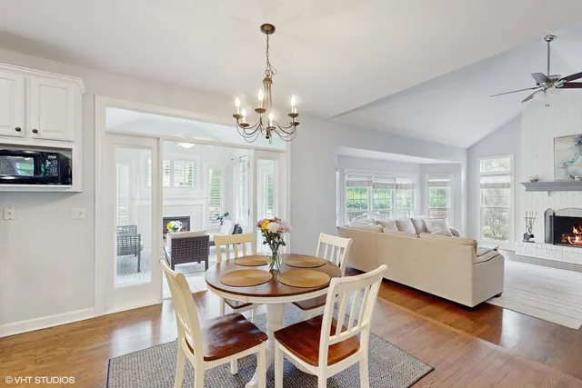a view of a dining room with furniture a chandelier and wooden floor