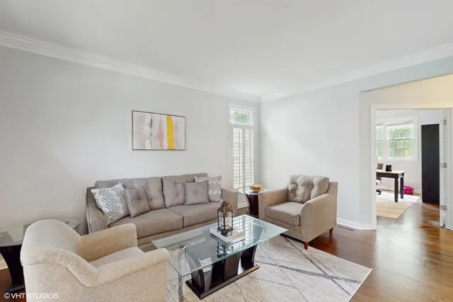 a living room with furniture wooden floor and a window