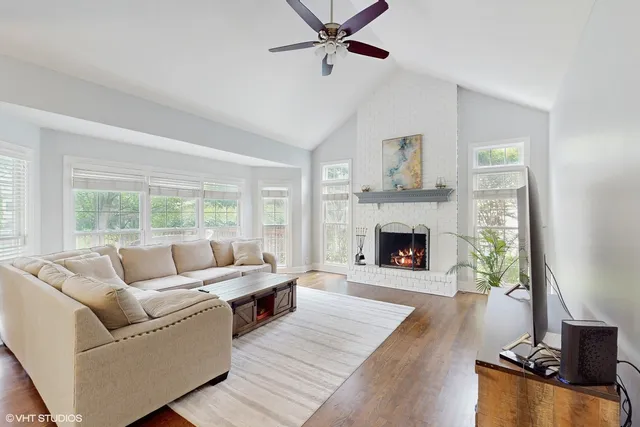 a living room with furniture large window and a fireplace