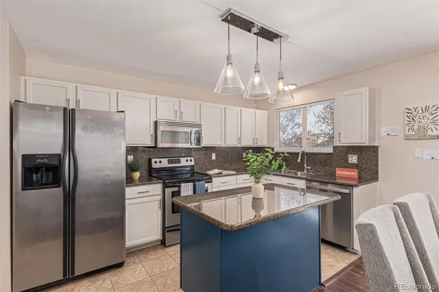 a kitchen with stainless steel appliances a sink a stove a refrigerator cabinets and a counter top space
