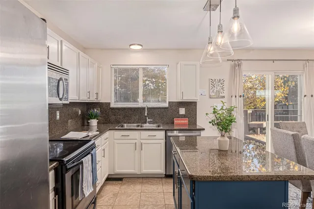 a kitchen with stainless steel appliances granite countertop a sink stove microwave and refrigerator