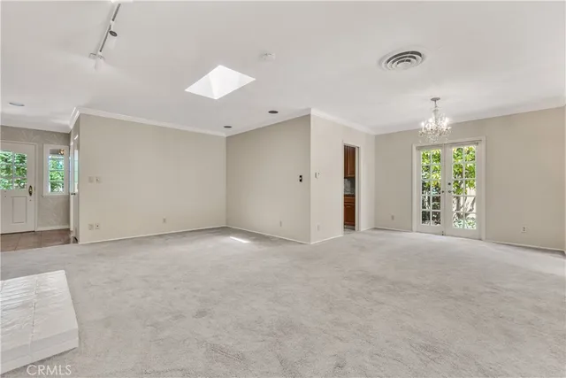 an empty room with windows and ceiling fan