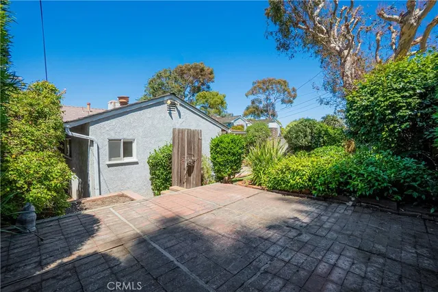 a view of a white house with a yard and plants
