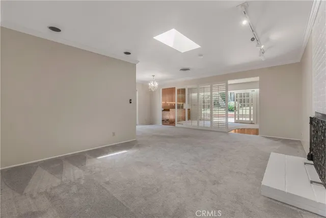 an empty room with floor to ceiling window and an outdoor view