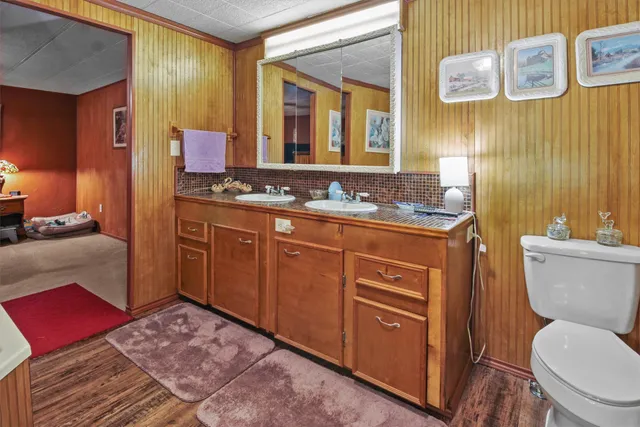 a bathroom with a granite countertop toilet sink and mirror