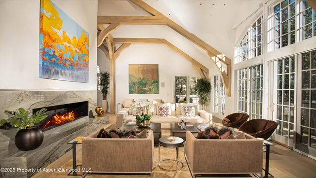 a living room with furniture a fireplace and a floor to ceiling window