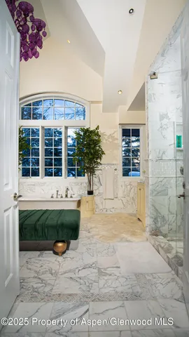 a spacious bathroom with a tub sink and mirror