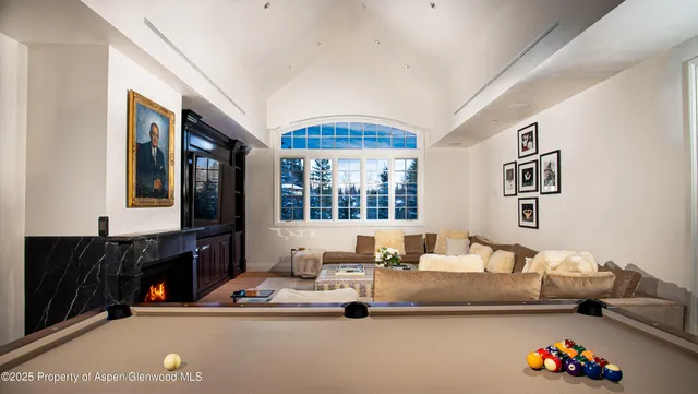 a living room with furniture a fireplace and a chandelier