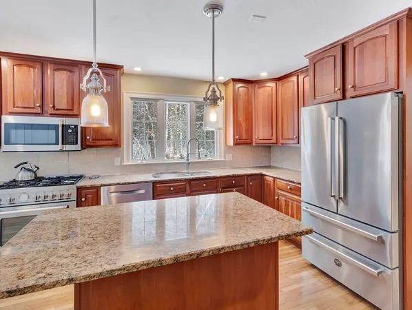 a kitchen with stainless steel appliances granite countertop a sink refrigerator and microwave