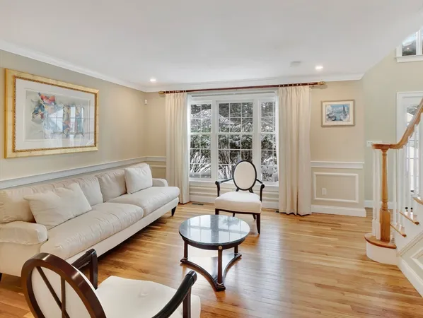 a living room with furniture and a painting on the wall