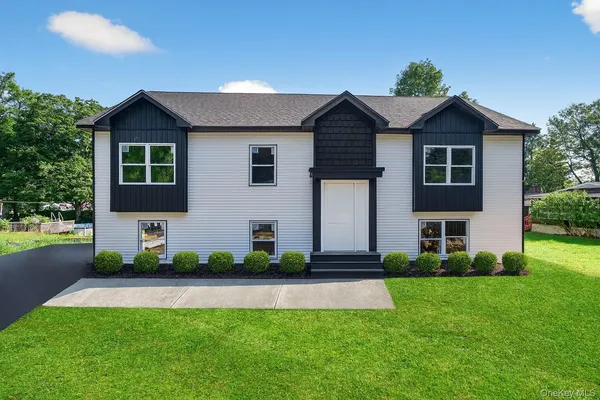 a front view of a house with a yard and potted plants