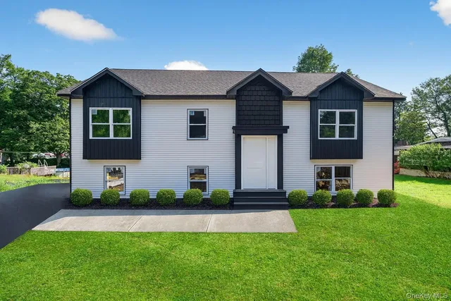 a front view of a house with a yard and potted plants