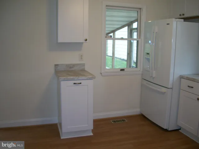 an empty room with wooden floor and a window