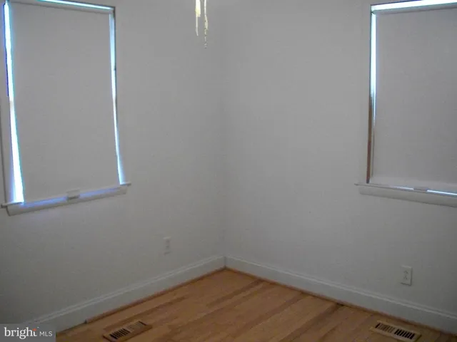 a view of a small space with wooden floor and a window