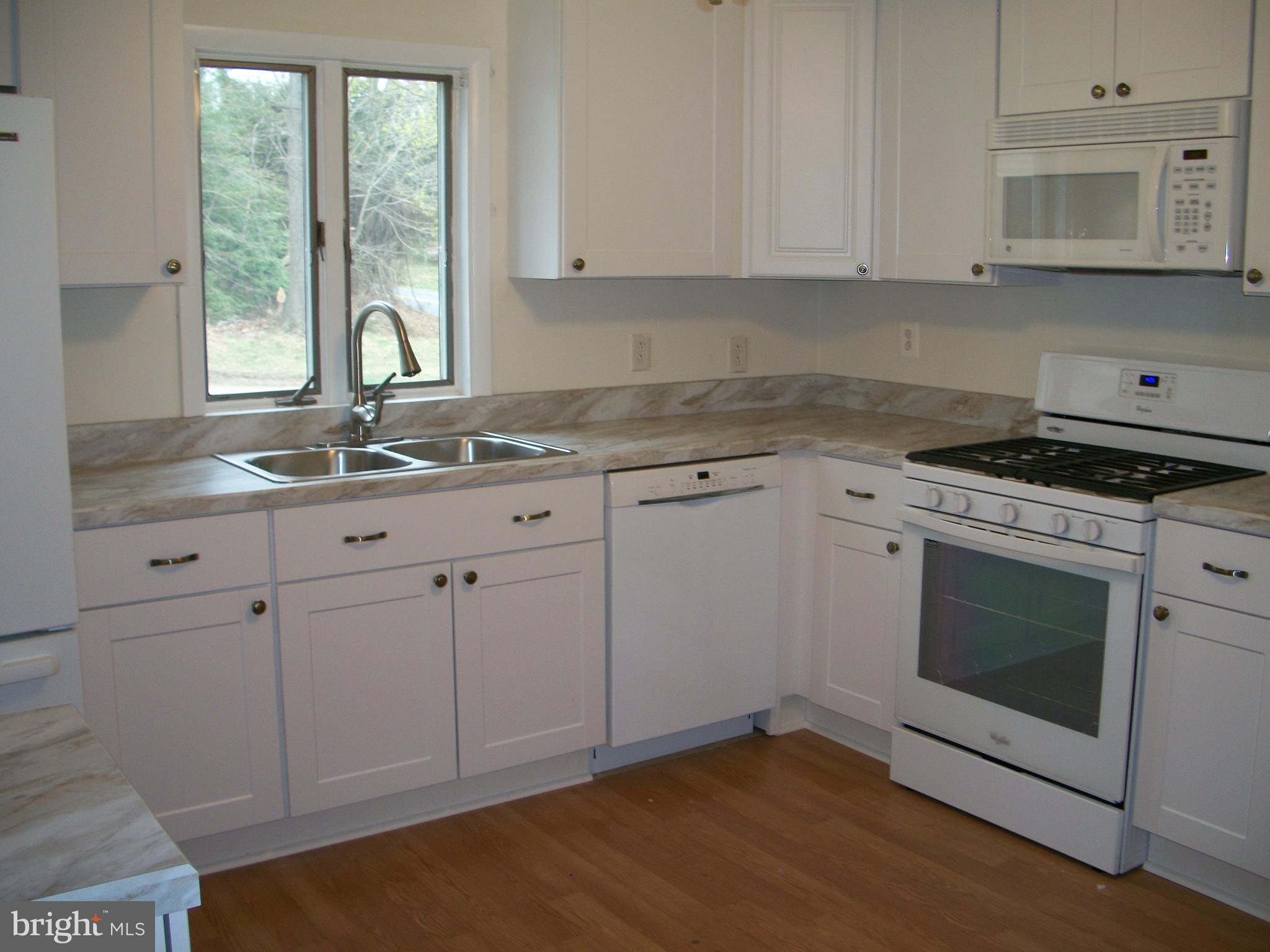 1102 Prospect Mill Road Bel Air, MD 21015 - Photo 8 of 18 a kitchen with granite countertop white cabinets stainless steel appliances a sink and a window